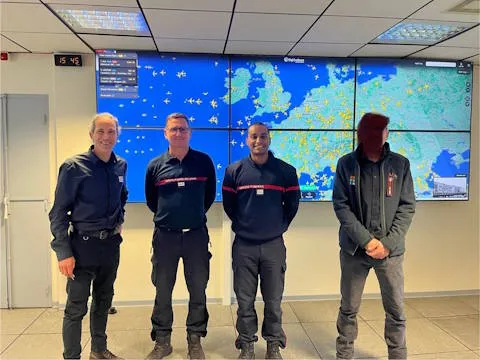 Équipe de sapeurs-pompiers devant leur mur d'images de commandement