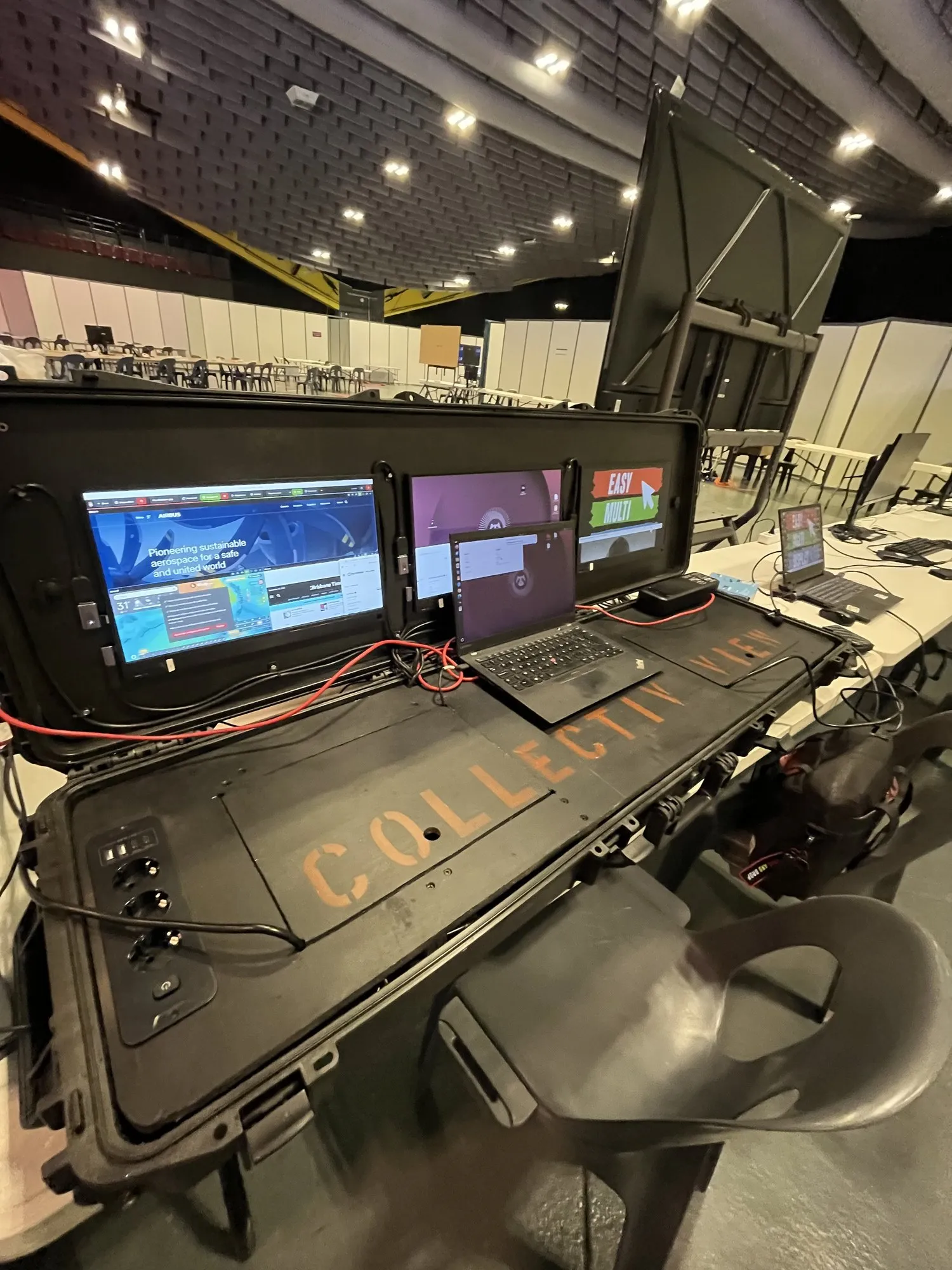 La maleta de mando vista de tres cuartos, sus dos pantallas encendidas, en la nave de la sala de control